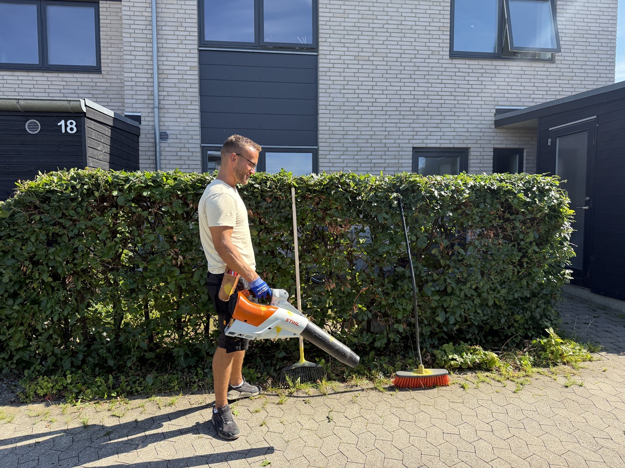Oprydning efter hækklipning i Måløv med løvblæser.